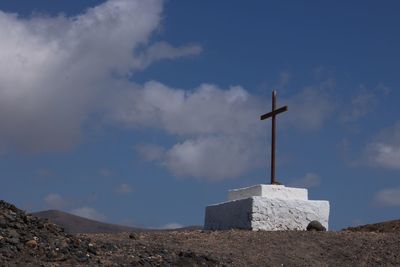 Low angle view of cross against sky