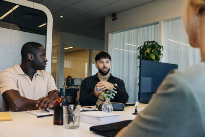 Businessman discussing with colleagues in meeting at coworking office