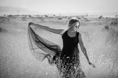 Young woman with eyes closed standing on grassy field