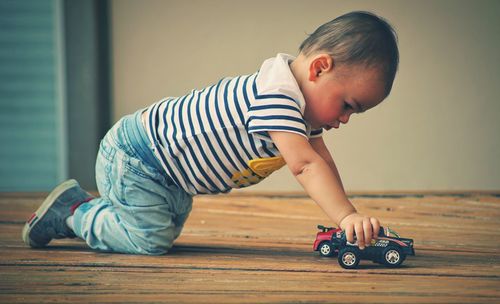 Boy playing with toy on floor