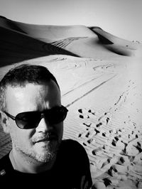 High angle portrait of mid adult man standing at desert during sunny day