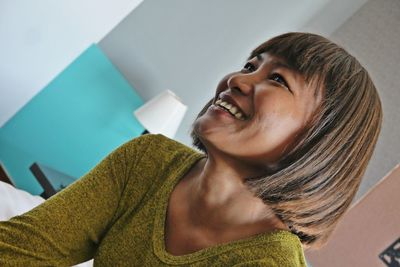Smiling woman with medium hair looking away at home