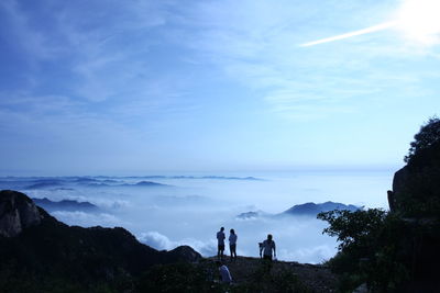 People standing on mountain against sky