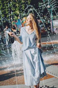 Fashion pretty cool young girl with shopping bags walking on a city street. young blonde woman 