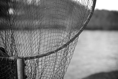 Close-up of fishing net against lake