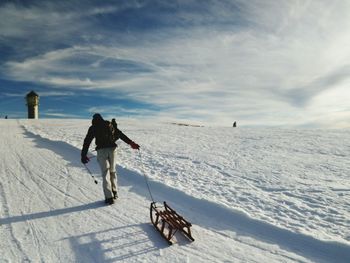 People skiing on snowcapped mountain against sky