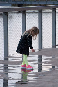 Full length of woman standing on wet umbrella