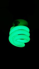 Close-up of illuminated lamp over black background