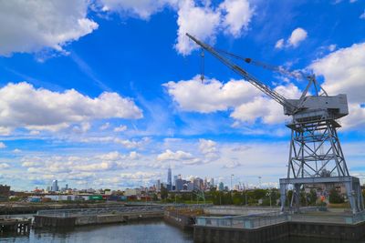 Bridge over river in city against sky