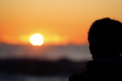 Rear view of silhouette man looking at sunset