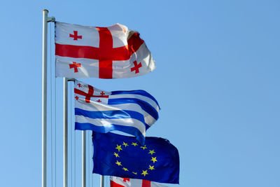 Low angle view of flag against blue sky