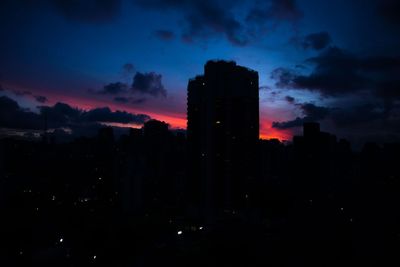 Silhouette buildings against sky at night