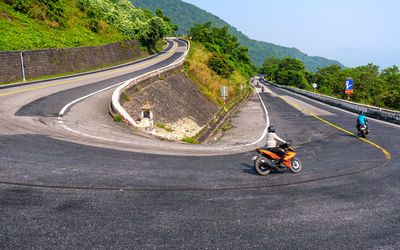 View of people riding motorcycle on road