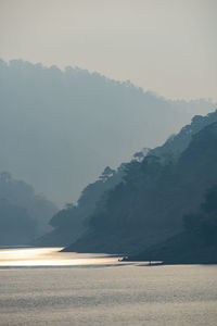 Scenic view of sea and mountains against sky