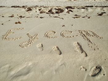 High angle view of footprints on sand at beach