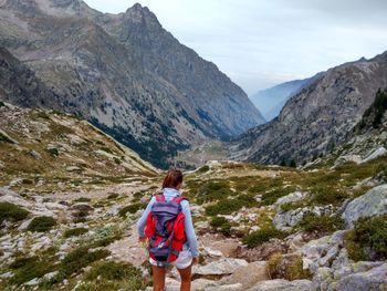 Rear view of man standing on mountain against sky
