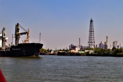 Commercial dock by sea against clear sky