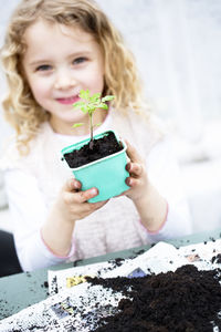 Girl holding seedling in pot