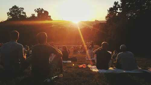 People enjoying on field in park during sunset