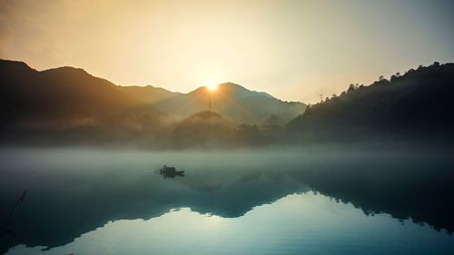 Scenic view of lake and mountains against clear sky