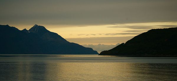 Scenic view of sea and mountains against sky during sunset