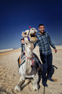 Portrait of people with camel in desert