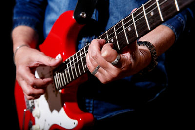 Midsection of man playing guitar