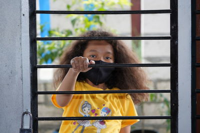 Portrait of woman holding glass window