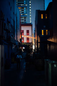 Street amidst buildings at night