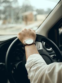 Cropped hand of man driving car