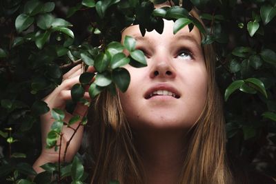 Close-up of young woman with fruits and leaves