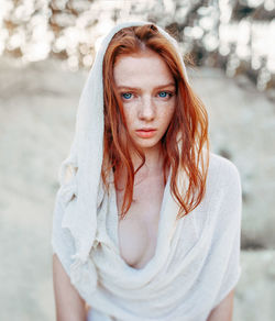 Portrait of beautiful woman wearing scarf while standing outdoors