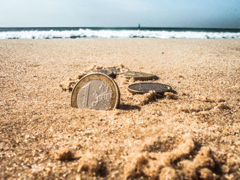 Text on sand at beach against sky