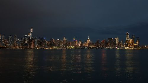 Illuminated buildings in city against sky at night