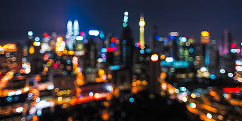 Defocuses image of illuminated petronas towers in city at night