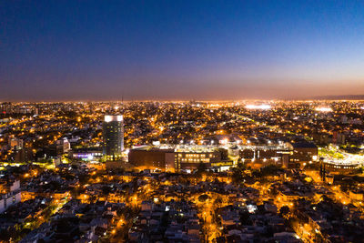 High angle view of illuminated city against clear sky at night