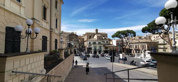 Street amidst buildings in city against sky