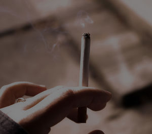 Close-up of hand holding cigarette