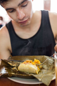 Close-up of man eating food on table at home