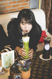 Portrait of a young woman drinking glass