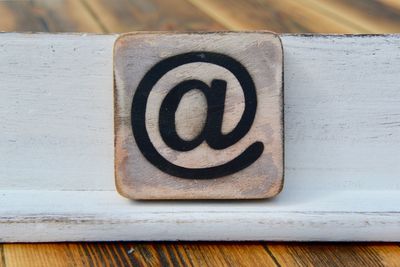 High angle view of at symbol on wooden table