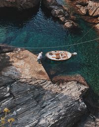 Aerial view of man on rocks by sea