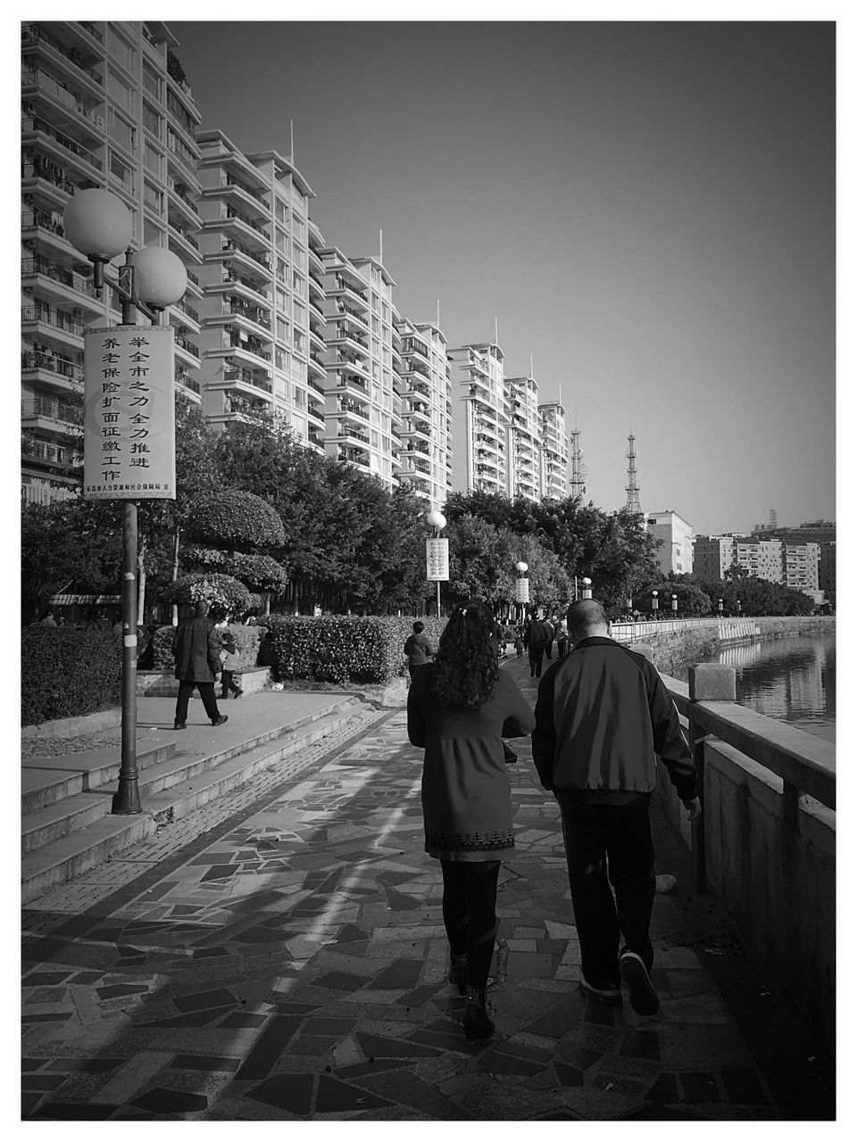 transfer print, building exterior, walking, architecture, men, built structure, full length, auto post production filter, lifestyles, rear view, city, street, person, city life, leisure activity, clear sky, casual clothing, day