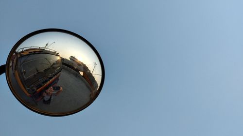 Reflection of vehicle in side-view mirror against sky