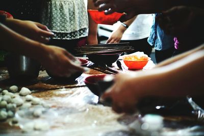 Midsection of people holding bowls on table