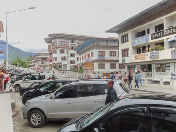 Cars on road in city against sky