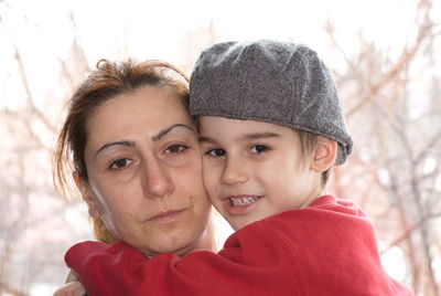 Close-up of mother and son against trees