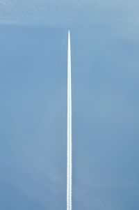 Low angle view of airplane flying against blue sky