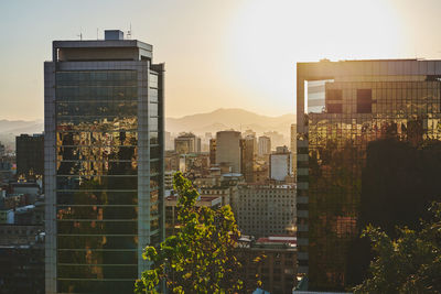 Buildings in city against sky during sunset