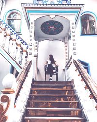 Low angle view of people standing on staircase in building